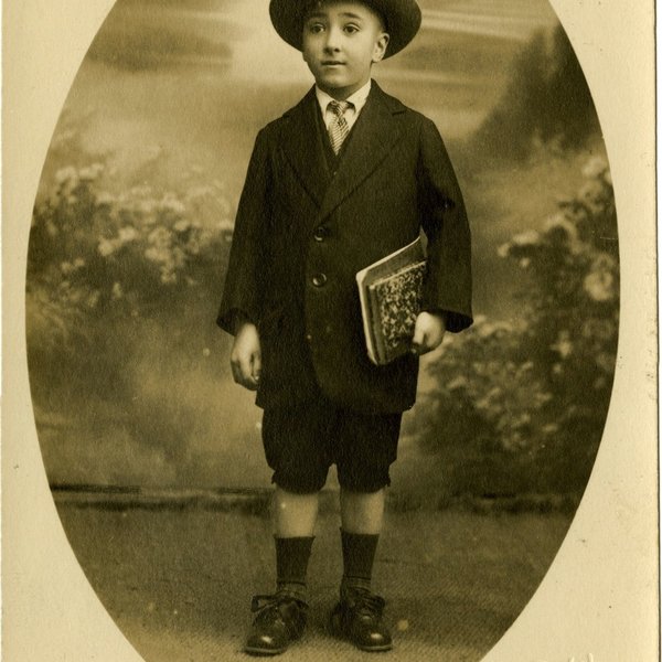 Soeiro Pereira Gomes com 7 anos, de fato e chapéu e com cadernos debaixo do braço, por Photograph...